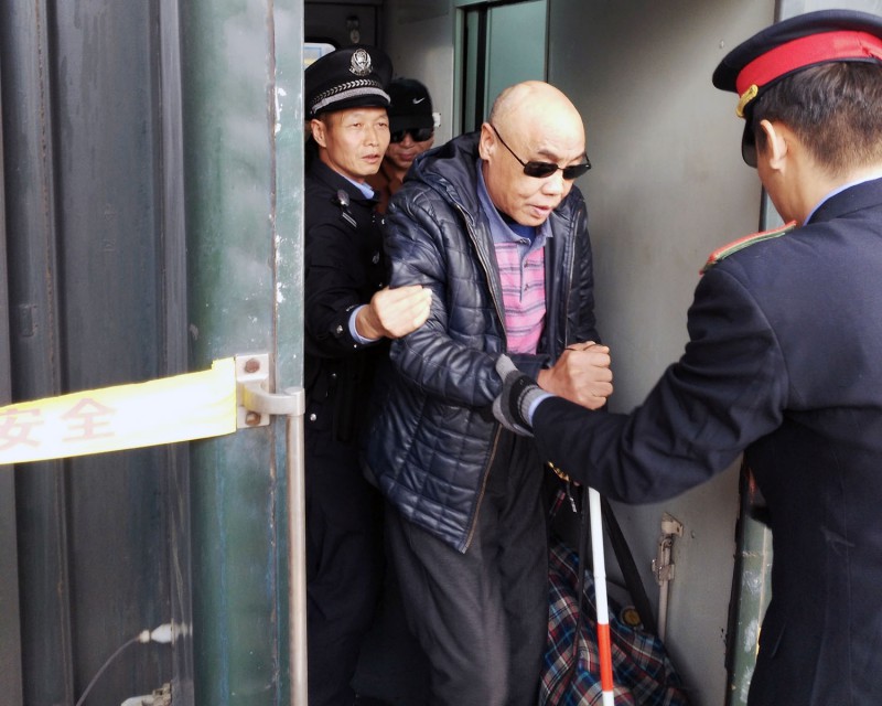 图7:老屈牵一个扶一个盲人下车