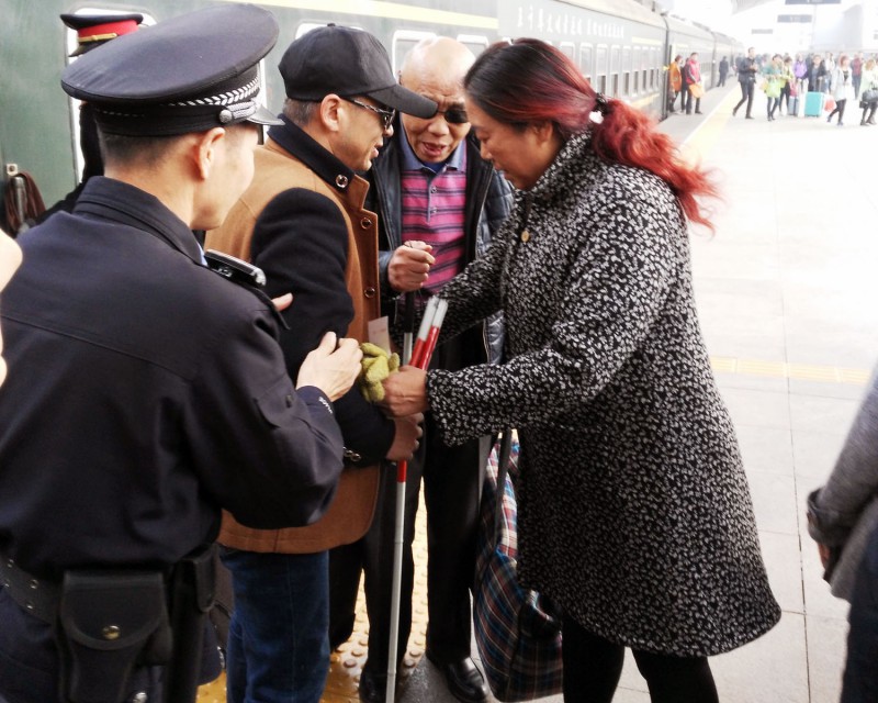图8:老屈手把手把盲人交给接站的亲人